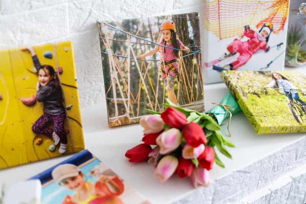 La imagen muestra fotografías impresas sobre lienzo colocadas como decoración en una repisa. Los colores vivos y las escenas al aire libre aportan un toque cálido, personal y lleno de recuerdos especiales al espacio.
