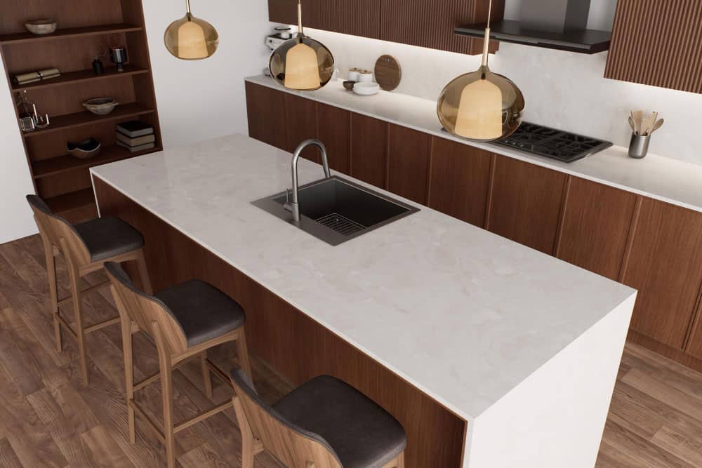 La imagen muestra una moderna isla de cocina con cubierta clara tipo mármol y gabinetes en acabado madera oscura, complementada con bancos altos de diseño contemporáneo.