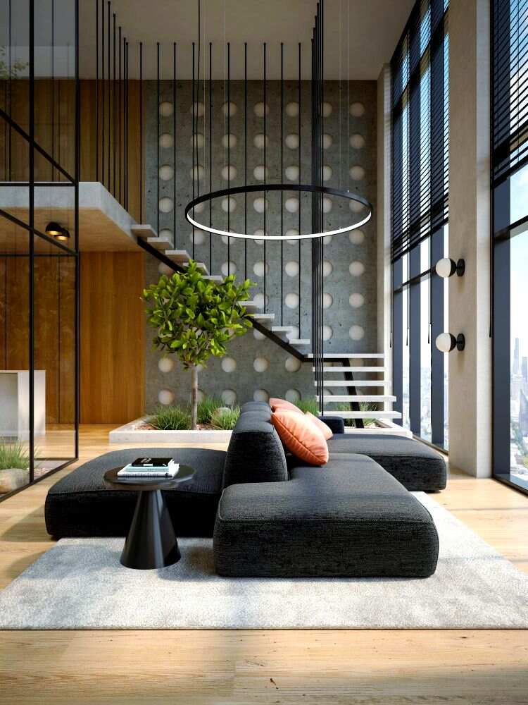 Un moderno espacio de doble altura con escaleras flotantes y grandes ventanales que inundan de luz natural. El mobiliario minimalista en tonos neutros, junto a elementos naturales y detalles industriales, crea un ambiente elegante, amplio y contemporáneo.