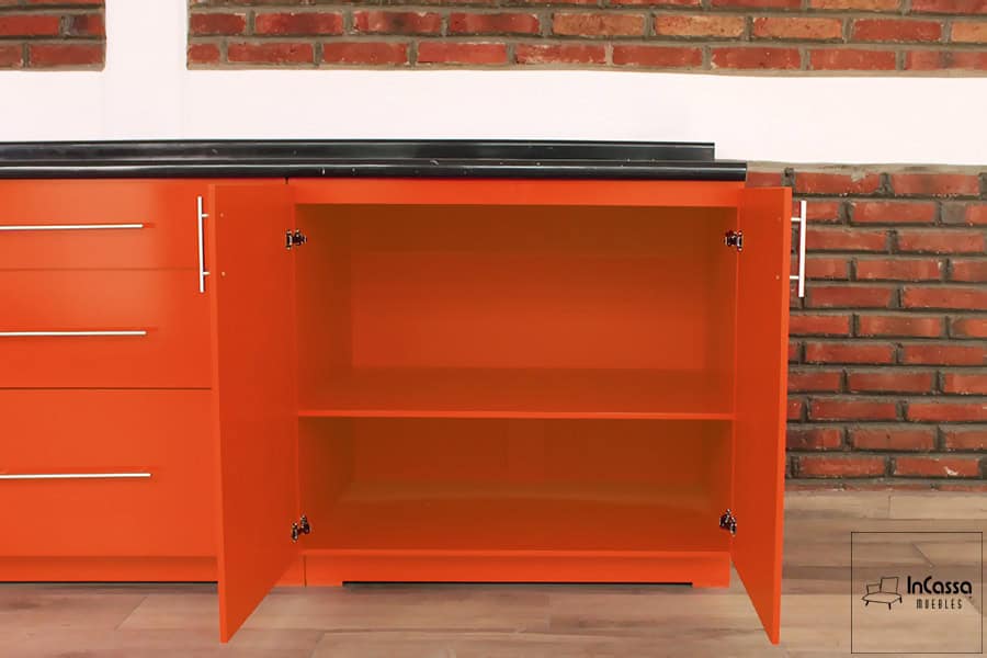 En esta toma podemos ver una de las partes interiores del módulo inferior, en la que se aprecian dos espacios divididos de manera horizontal por un entrepaño. La parte interior conserva en su totalidad el color naranja al igual que los exteriores de mueble.