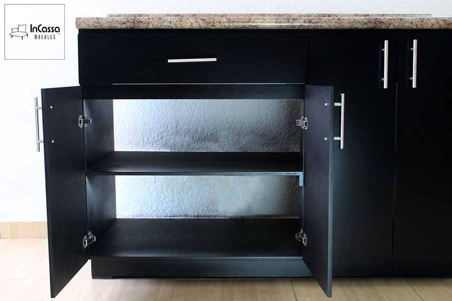 Vista frontal de la sección izquierda del módulo inferior de la Cocina ALMEIRA, donde se aprecian dos amplios compartimentos interiores con una repisa central. Las puertas están abiertas para mostrar la capacidad de almacenaje y los herrajes metálicos de cierre suave, además del acabado chocolate completo del mueble.