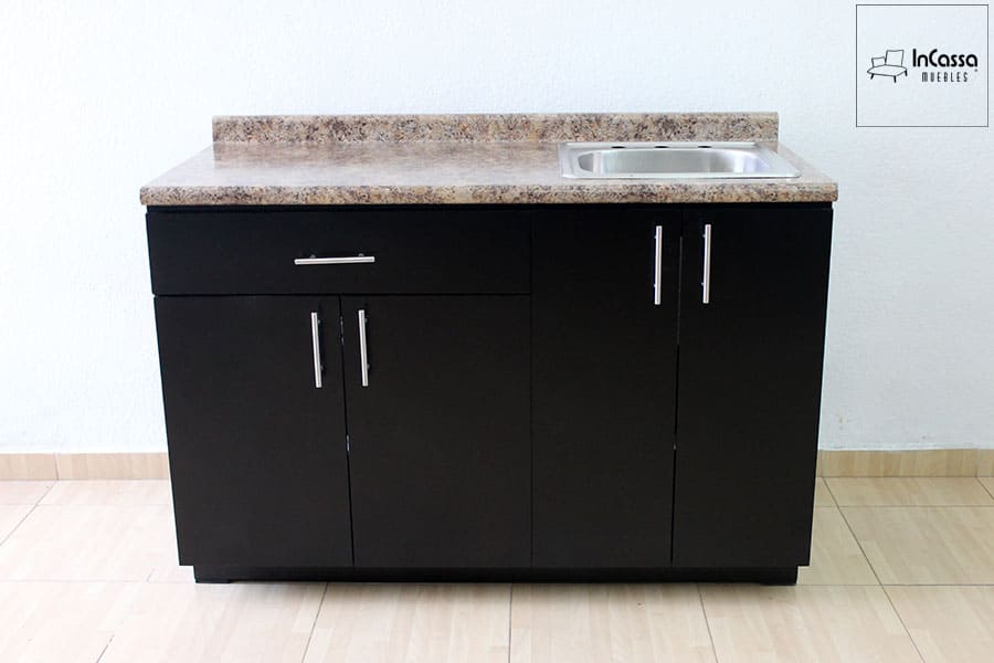 La imagen muestra el módulo inferior de la cocina integral ALMEIRA, fabricado en tono chocolate con cubierta de formaica estilo piedra salvaje y tarja de acero inoxidable del lado derecho. Cuenta con una puerta doble central, un cajón funcional y amplio espacio de almacenamiento.