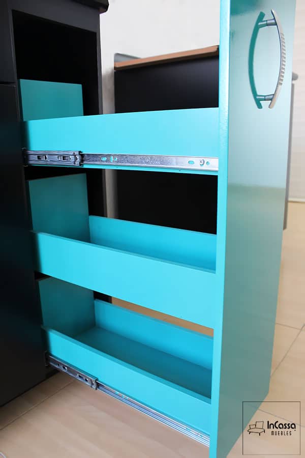Esta vista destaca el Especiero de la Cocina integral AMSTERDAM de 2.10m para ESTUFA en color turquesa, parcialmente extraído para mostrar su estructura deslizante y las correderas metálicas laterales. Su diseño aprovecha al máximo el espacio disponible, facilitando la organización de condimentos, frascos y artículos de uso frecuente.