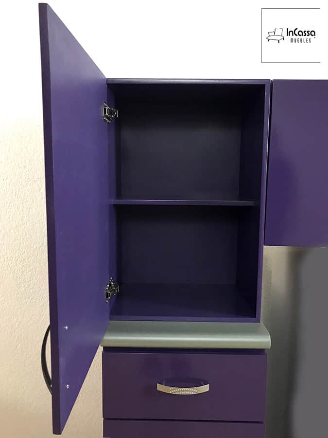 Una imagen de la alacena superior de la cocina, presentada con su puerta abierta dejando ver un espacio dividido por un entrepaño horizontal en dos compartimentos. El interior de la alacena mantiene el mismo color morado que puede verse en toda la cocina.