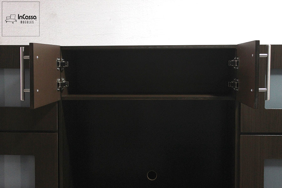 Una fotografía muestra la alacena central del mueble en color chocolate, con puertas abatibles abiertas hacia los lados. Su interior es amplio y sin divisiones, ideal para instalar horno de microondas o almacenar utensilios grandes.