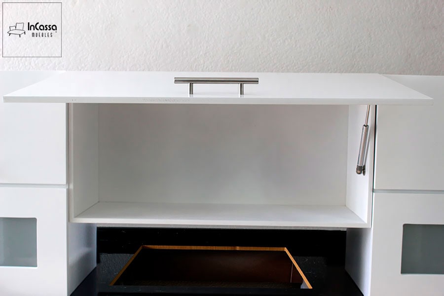 Una toma frontal del módulo central superior blanco de la cocina AUSTRIA muestra un compartimento amplio con puerta abatible sostenida por pistón neumático, ideal para almacenar utensilios ligeros.