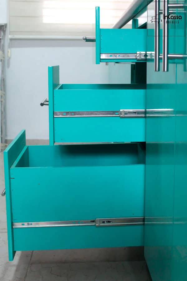 Se presenta un detalle de los cajones inferiores de lo cocina, diseñados para un almacenamiento organizado. Cada cajón es de color menta completo, e incluye rieles metálicos que aseguran un deslizamiento suave y resistencia.