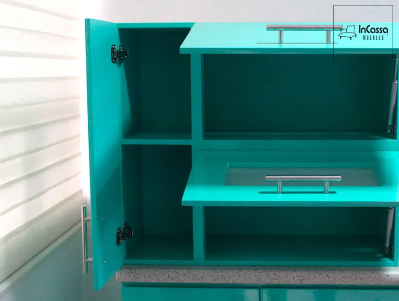 La imagen muestra el interior del gabinete superior de la cocina en color menta completo. Cuenta con compartimentos amplios y una puerta abatible con cristal esmerilado, ideal para organizar utensilios de cocina.