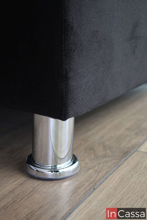 Vemos un toma cercana de una de las patas delanteras que sostienes que módulo de la sala, la cual es metálica con un acabado cromado. También podemos ver más de cerca la textura de la tela suede de la que esta tapizado ese módulo.