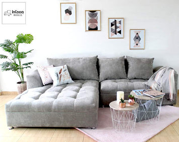 En esta imagen se aprecia la Sala Esquinera modelo BANGLADÉS en su elegante versión tapizada en suede gris perla. Su diseño incluye asientos capitonados con cojines amplios y respaldo alto, creando un espacio moderno, confortable y sofisticado.