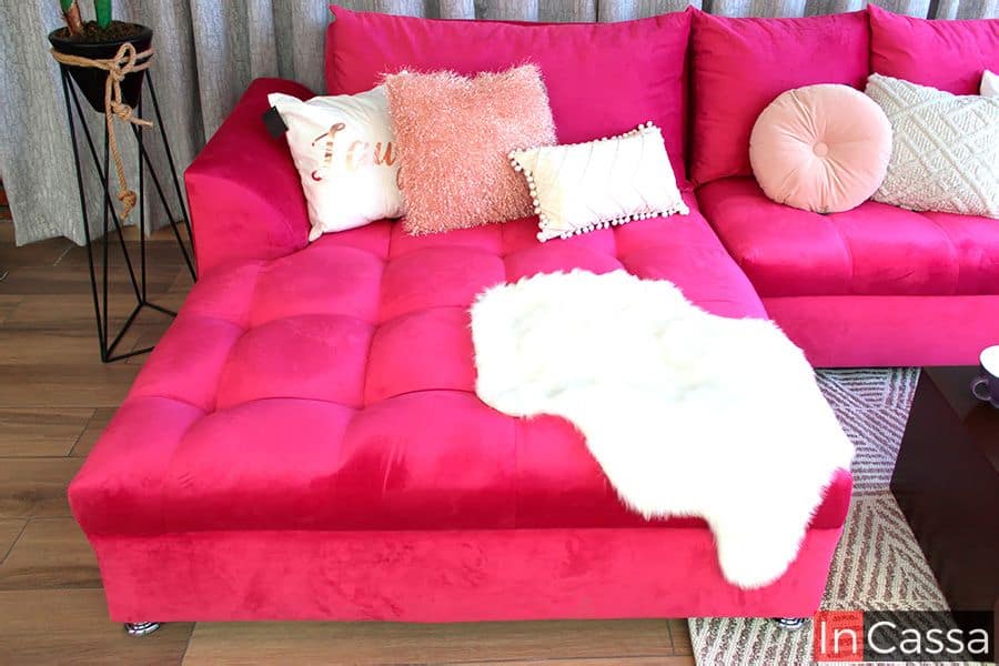 La chaise longue de la Sala Bangladés tapizada en suede fucsia se muestra con capitonado elegante y cojines decorativos que aportan textura y contraste. El asiento amplio garantiza comodidad, mientras que el acabado en terciopelo resalta con un brillo sofisticado.