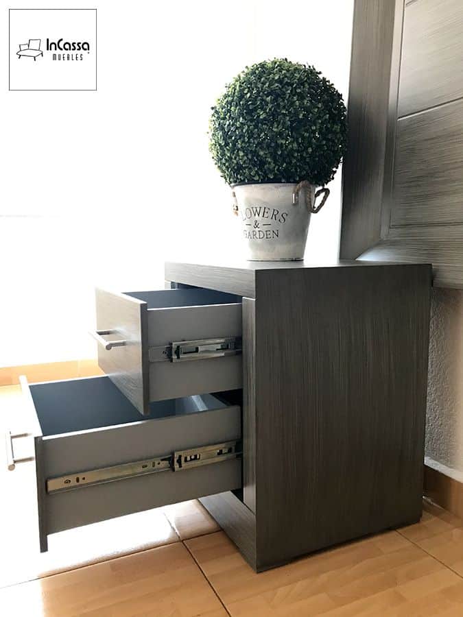 Una vista cercana del buró modelo Barcelona en tono gris cenizo oscuro muestra sus dos cajones abiertos con correderas metálicas de extensión. Ideal para almacenar objetos personales con un estilo moderno y funcional.