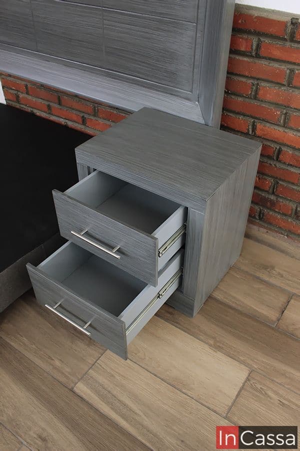 La imagen muestra el buró del modelo Barcelona en color gris cenizo oscuro, capturado desde un ángulo superior. Los dos cajones están abiertos, revelando el sistema de correderas metálicas de extensión y el interior en tono gris claro.