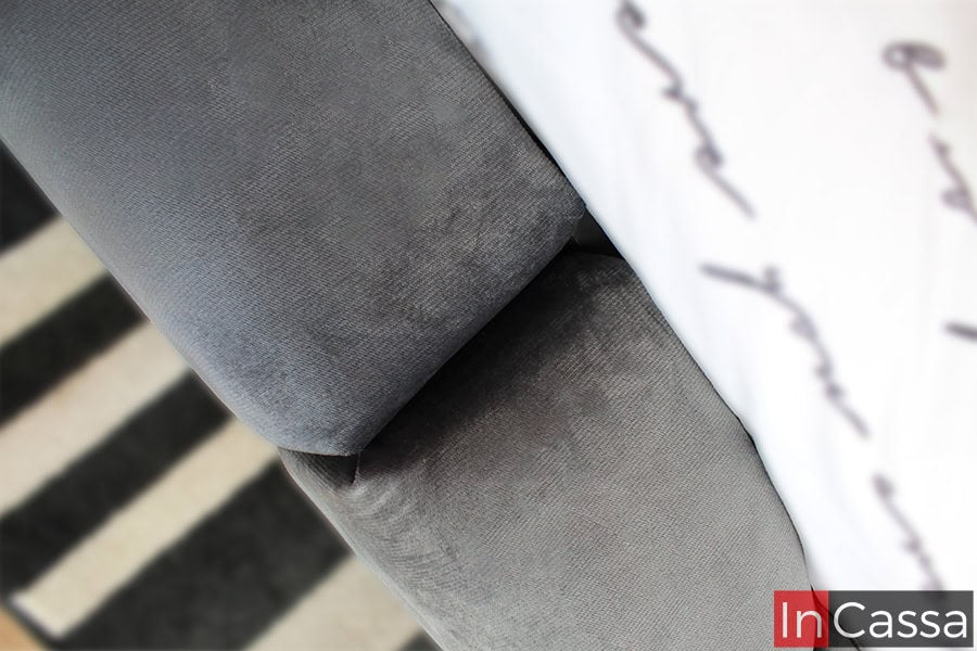 Un acercamiento al borde de la base, resaltando la perfecta ejecución del acolchado en el tapiz suede gris oxford que suaviza los bordes y aporta un toque contemporáneo sin dejar de ser funcional.
