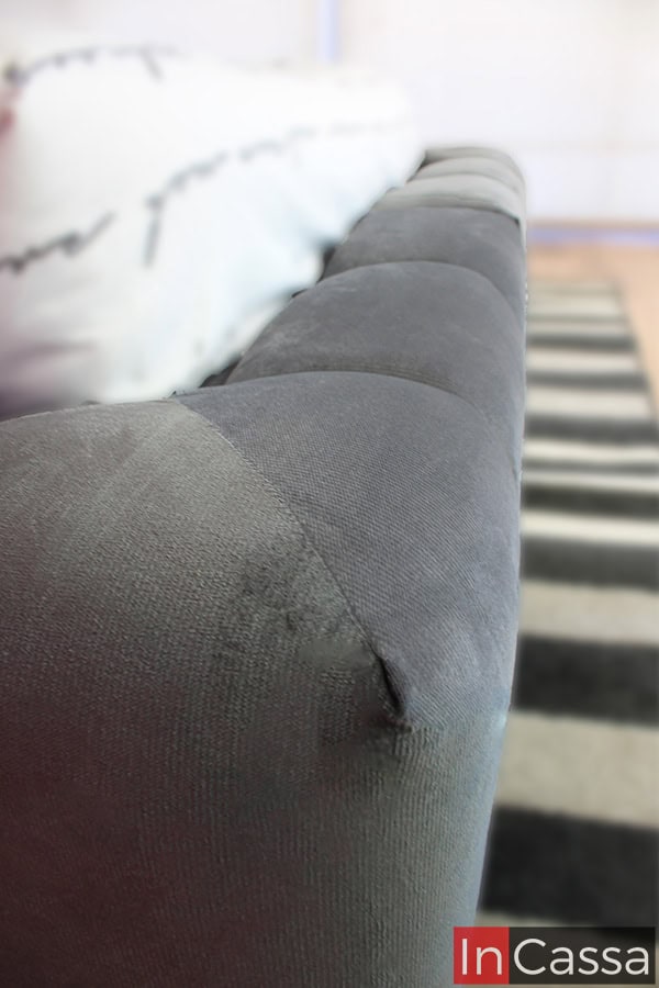 En esta imagen, se aprecia en detalle el acabado de las esquinas de la base, que combina líneas suaves con un acolchonado generoso. La confección precisa en el tapizado gris oxford asegura una estética elegante y uniforme en todo el perímetro.