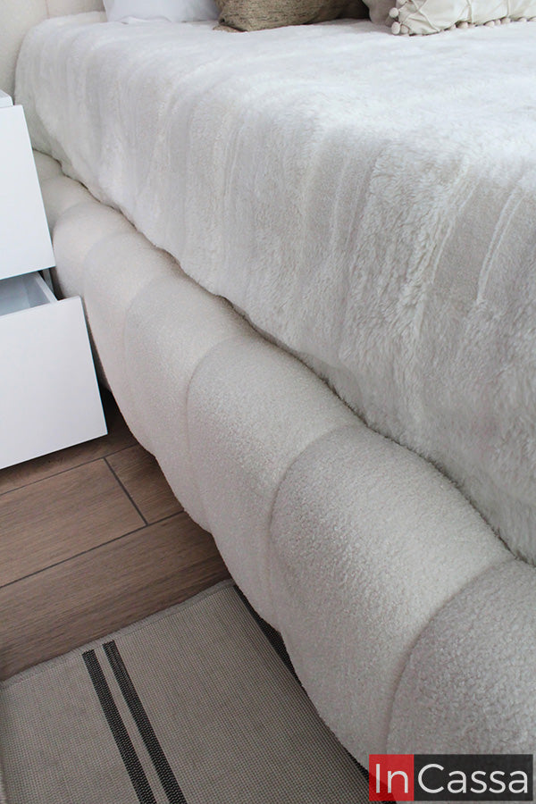 Una toma lateral de la Base de Cama Viral Estilo Pinterest modelo SEDONA tapizada en suede hueso resalta su diseño acolchado tipo nube y textura suave, creando una apariencia elegante, acogedora y perfecta para recámaras contemporáneas.