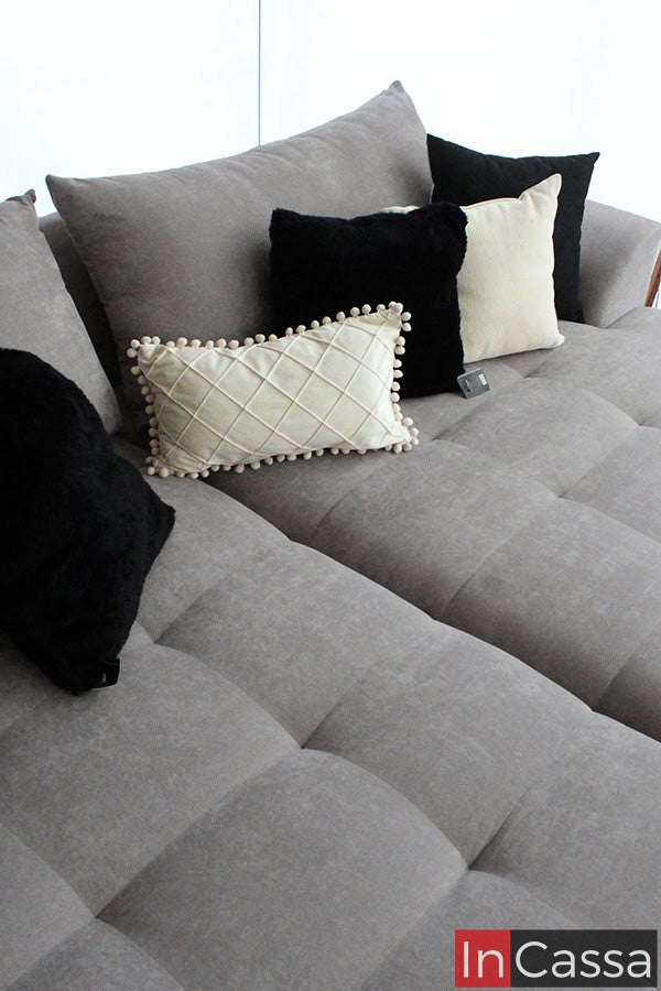 Un enfoque en los los asientos y respaldos de la sala, decorados con cojines decorativos. Los colores neutros, como el negro y el beige, junto con texturas elegantes, brindan un toque de sofisticación al diseño minimalista del mobiliario.