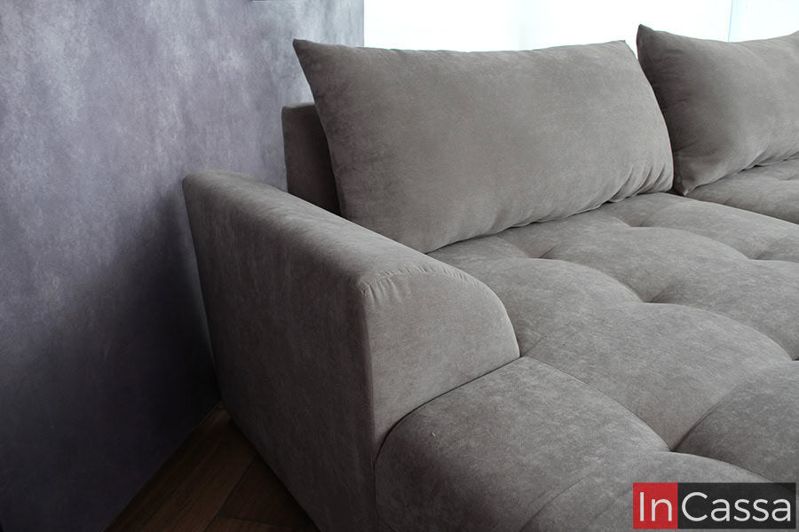 En esta toma se puede apreciar el diseño del reposabrazos de la sala de suede gris perla, con líneas suaves y acolchado cómodo que se integran perfectamente en el diseño general, proporcionando un espacio acogedor para descansar.