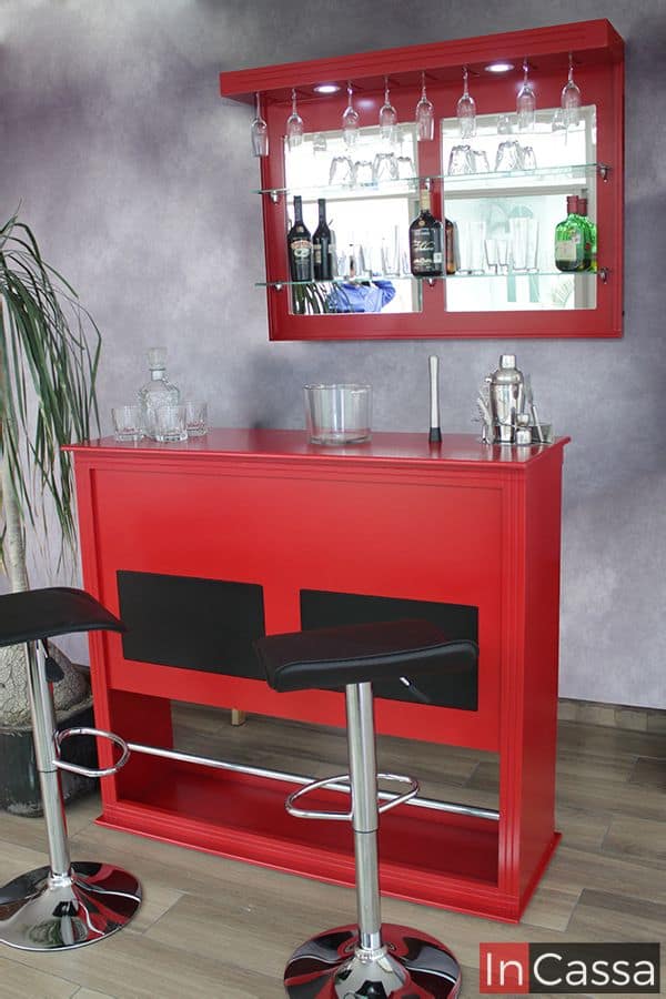 La imagen muestra la Cantina Bonn en vibrante color rojo vivo con cuadros decorativos negros, acompañada de dos bancos Urbino tapizados en negro con base cromada y reposapiés. El mueble incluye repisas de cristal, soportes para copas colgantes e iluminación LED, logrando un estilo moderno, elegante y lleno de carácter.