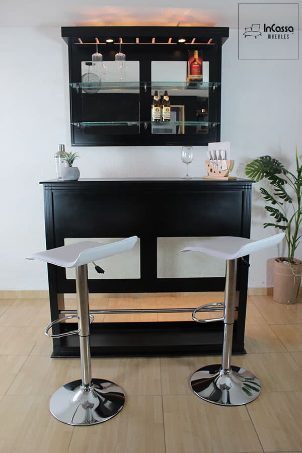 La foto presenta la elegante Cantina Bonn en acabado color chocolate con cuadros decorativos blanco, acompañada por dos bancos modelo Urbino en tono blanco con bases cromadas. Un diseño moderno con repisas de vidrio y soportes para copas que realza cualquier espacio.