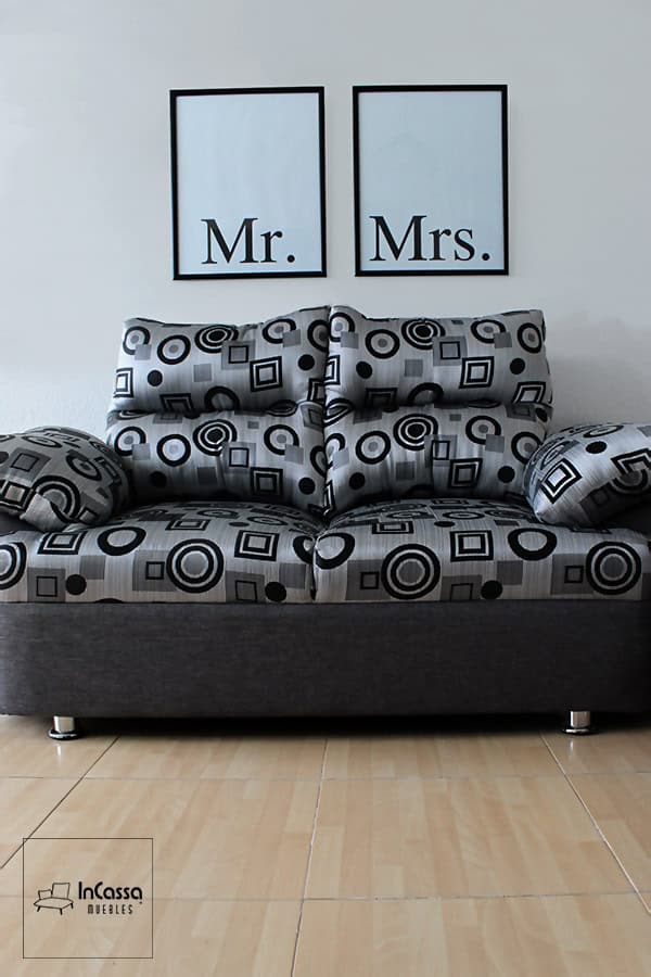 Se presenta el love seat de la Sala Modelo Bora Bora tapizado en lino estilo geométrico gris, con diseños circulares y cuadrados en tonos oscuros. Sus cojines acolchados de gran volumen brindan comodidad, mientras que la base en tono gris oscuro y las patas cromadas completan un diseño elegante y contemporáneo ideal para salas modernas.