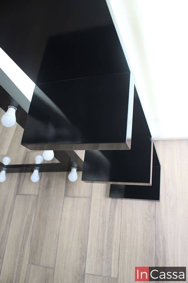 Los estantes de la estación de tocador negra, en una disposición en ángulo, crean un diseño visualmente atractivo y dinámico. Cada estante ofrece suficiente espacio para organizar productos y accesorios, aportando funcionalidad y estilo a cualquier área de vestidor.