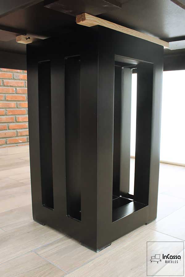 La imagen muestra un acercamiento detallado a la robusta base del comedor Brasil, diseñada con formas rectangulares y acabado en color chocolate, aportando estabilidad y un estilo contemporáneo al conjunto.