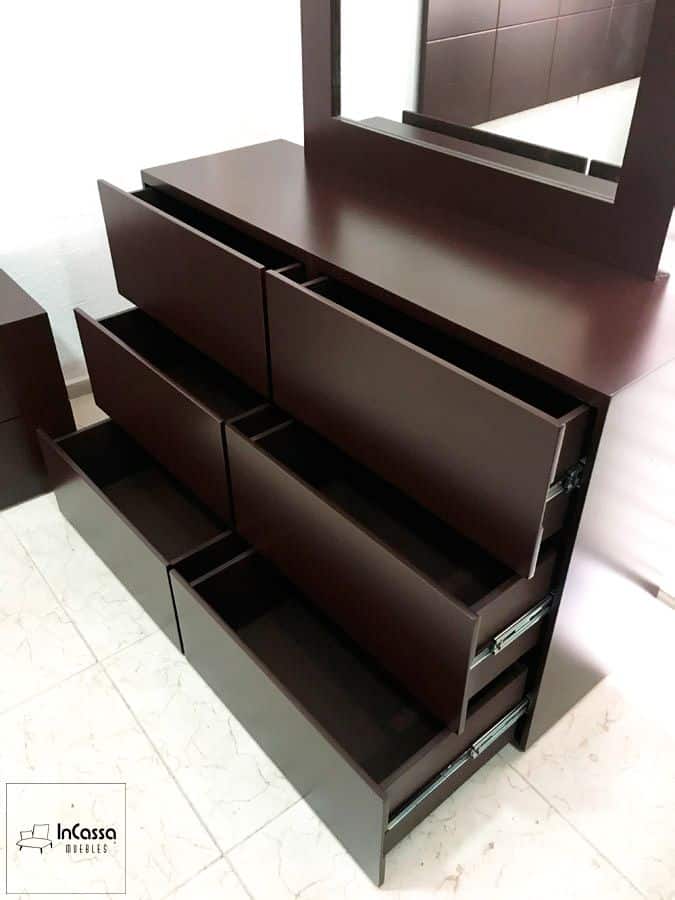 La imagen resalta la funcionalidad del tocador del Modelo BRASILEA, mostrando sus seis cajones abiertos con correderas metálicas de extensión completa. Fabricado en MDF color chocolate, ofrece gran capacidad de almacenamiento y un acabado moderno de líneas limpias.