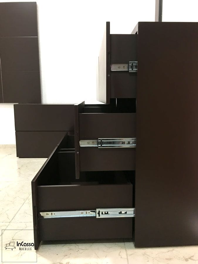 La toma lateral del tocador del Modelo BRASILEA exhibe la apertura de sus cajones con correderas metálicas visibles, garantizando un deslizamiento suave y resistente. Su estructura en MDF color chocolate refuerza el estilo moderno y minimalista del conjunto.