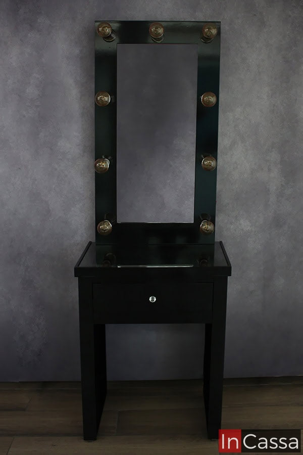 Se presenta el tocador negro en una toma frontal con los focos LED de su espejo apagados, destacando de esta manera el acabado brillante de la pintura negra, la cuál es bastante notable aun con la falta de la iluminación del los focos LED.