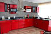 Una toma de la moderna cocina integral en U, diseñada en un vibrante tono rojo que resalta con cubierta de formaica estilo mármol negro. Sus múltiples módulos ofrecen almacenamiento amplio, mientras que los gabinetes superiores incluyen puertas de cristal esmerilado para un toque elegante. Esta cocina integra un diseño en U funcional, ideal para optimizar espacios, con áreas específicas para electrodomésticos como microondas y campana extractora. Un modelo que combina estilo y funcionalidad.