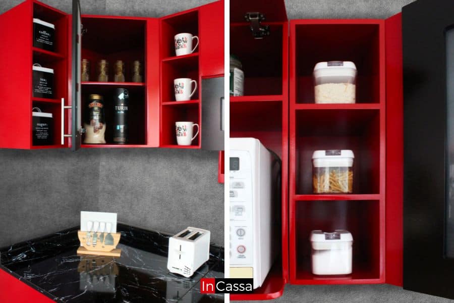 La imagen destaca los módulos superiores laterales de la cocina, ideales para organizar tazas, alimentos o utensilios, con prácticos estantes y puertas de diseño moderno en acabado rojo brillante.