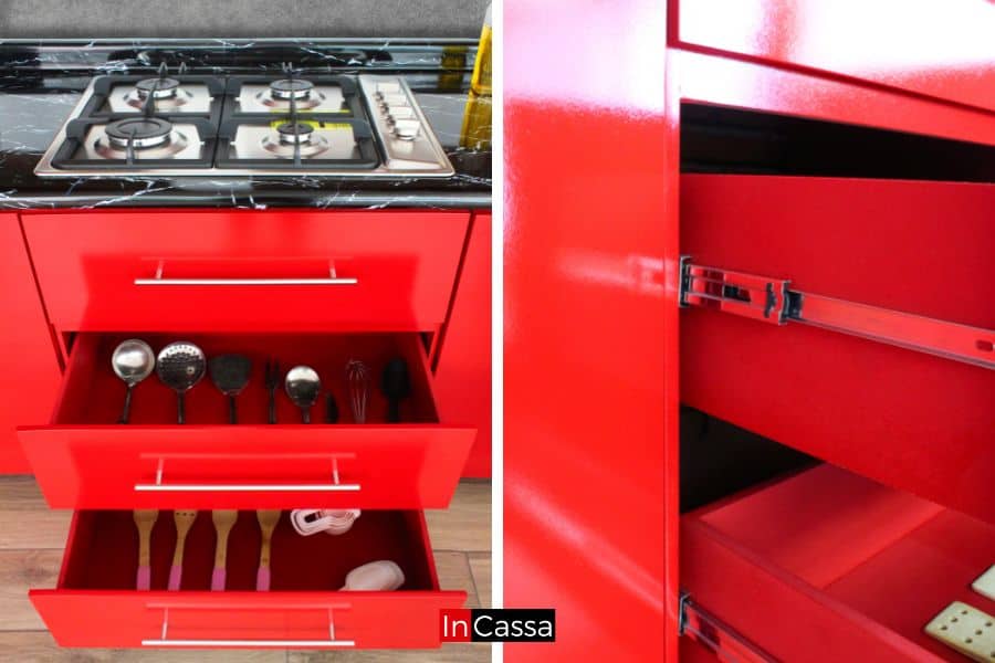 Una fotografía de los cajones de la cocina, ideales para utensilios de cocina y accesorios. El vibrante color rojo completo resalta sobre la cubierta de formaica negra marmoleada, mientras que los rieles deslizantes garantizan suavidad y durabilidad.