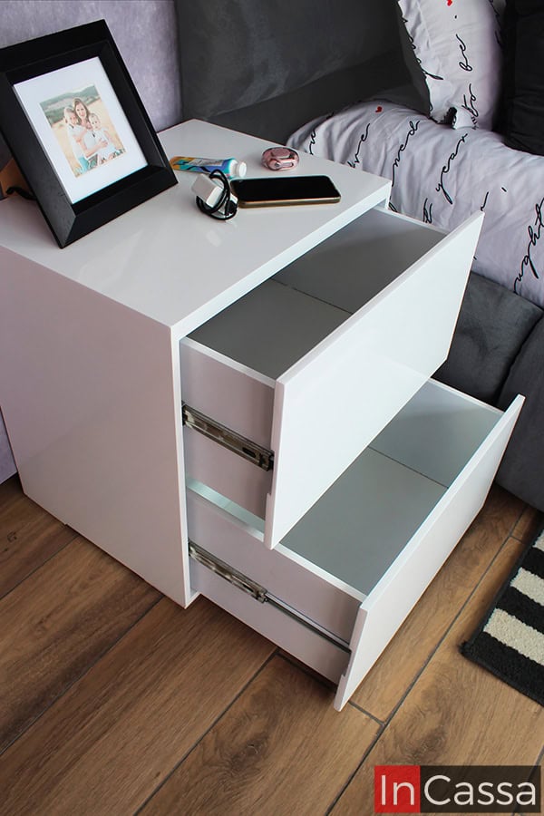 La imagen muestra un enfoque en los cajones del buroe blanco, que ofrecen un mecanismo con rieles metálicos de apertura suave y amplio espacio para guardar artículos personales. Un complemento funcional y elegante para la cama.