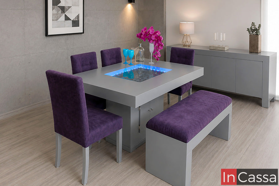 En la imagen se aprecia el Comedor con luz Modelo BUSAN para 6 personas en color silver con asientos tapizados en suede morado, una propuesta que combina diseño contemporáneo y sofisticación. Su mesa con iluminación integrada y cómodos asientos crean un ambiente elegante, ideal para disfrutar reuniones y momentos especiales.