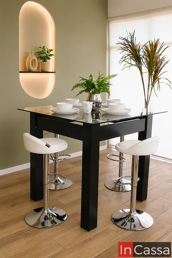 Se aprecia el Comedor Alto Modelo CABRERA para 4 personas en color chocolate con cubierta de cristal y bancos neumáticos tapizados en tacto piel color blanco. Su diseño elevado de estilo contemporáneo aporta elegancia y funcionalidad, siendo ideal para cocinas, barras o espacios modernos donde se busca comodidad y un ambiente sofisticado.