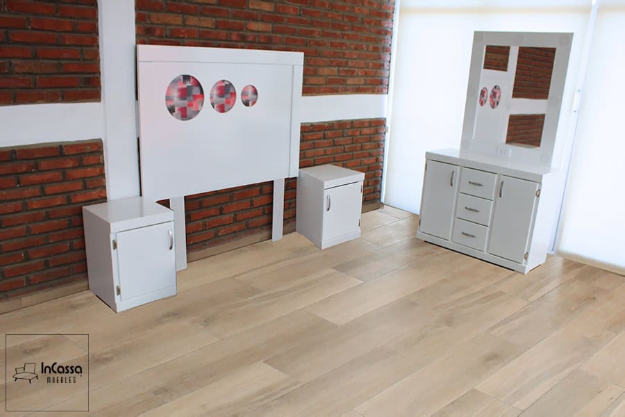 Se presenta el conjunto de recámara en blanco, compuesto por cabecera decorada con círculos tapizados en lino plasma, dos burós con puertas y un tocador tipo vanity con espejo y focos LED. Un diseño juvenil, moderno y funcional para espacios luminosos.