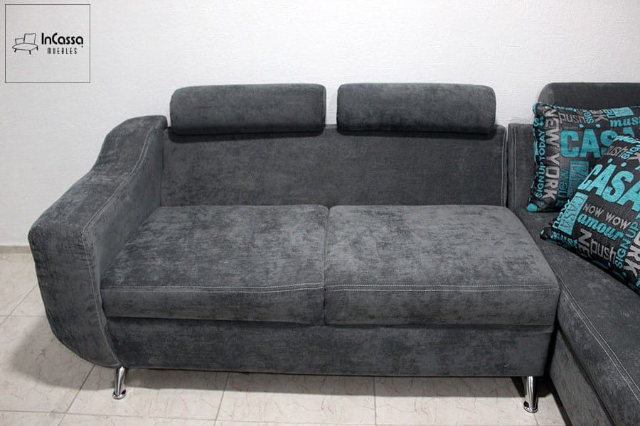 Sala esquinera de suede gris con reposacabezas ajustables y patas metálicas cromadas. Ideal para una sala de estar moderna que busca combinar elegancia y confort en un solo mueble.