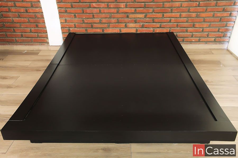 La imagen muestra una base de cama en acabado chocolate mate con líneas modernas y bordes elevados. Su estructura robusta proporciona estabilidad, mientras que su diseño minimalista la convierte en una opción sofisticada para cualquier dormitorio.