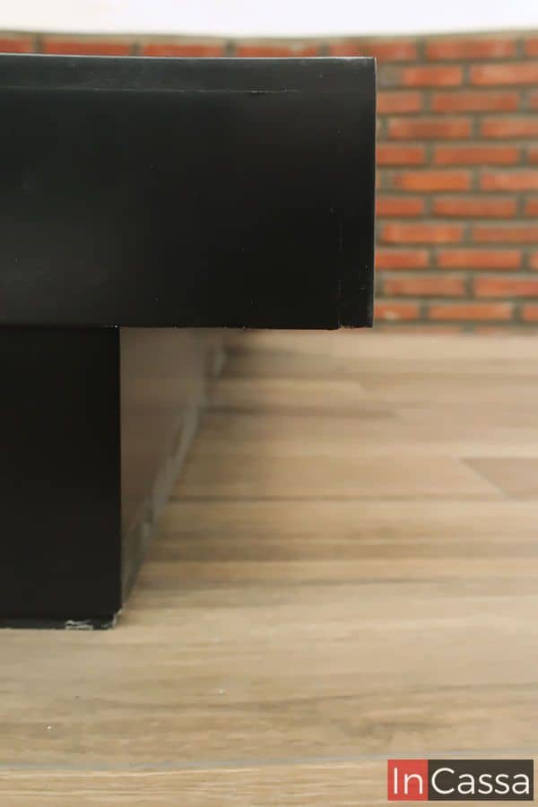 La imagen muestra un acercamiento al lateral de la base de cama en acabado chocolate mate. Su diseño de perfil bajo con bordes elevados brinda un soporte firme y elegante, fusionando estética y funcionalidad para complementar espacios modernos.