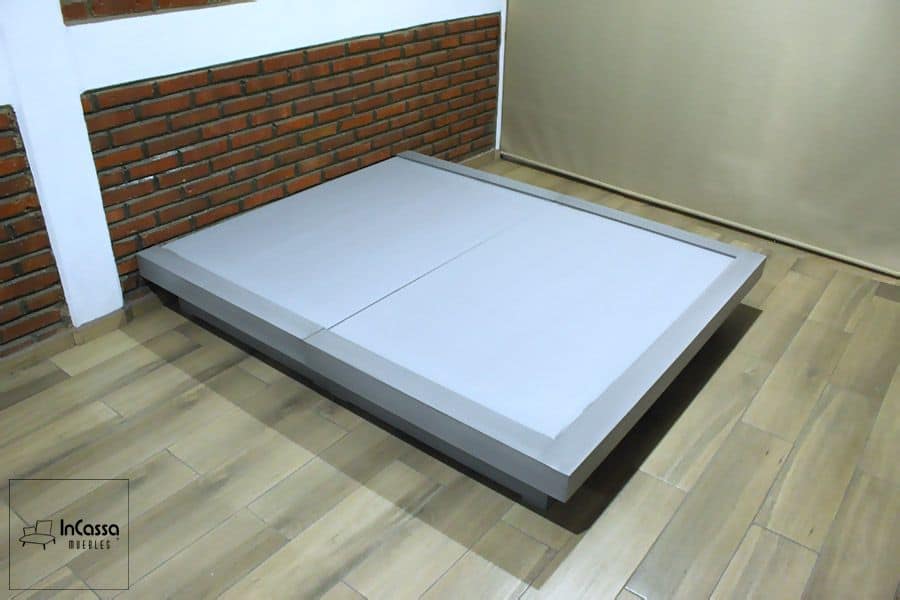 Se presenta una base de cama en color gris cenizo claro con diseño de perfil bajo y bordes elevados. Su estructura sólida y moderna aporta estabilidad y un toque sofisticado, ideal para complementar dormitorios contemporáneos con un estilo minimalista.