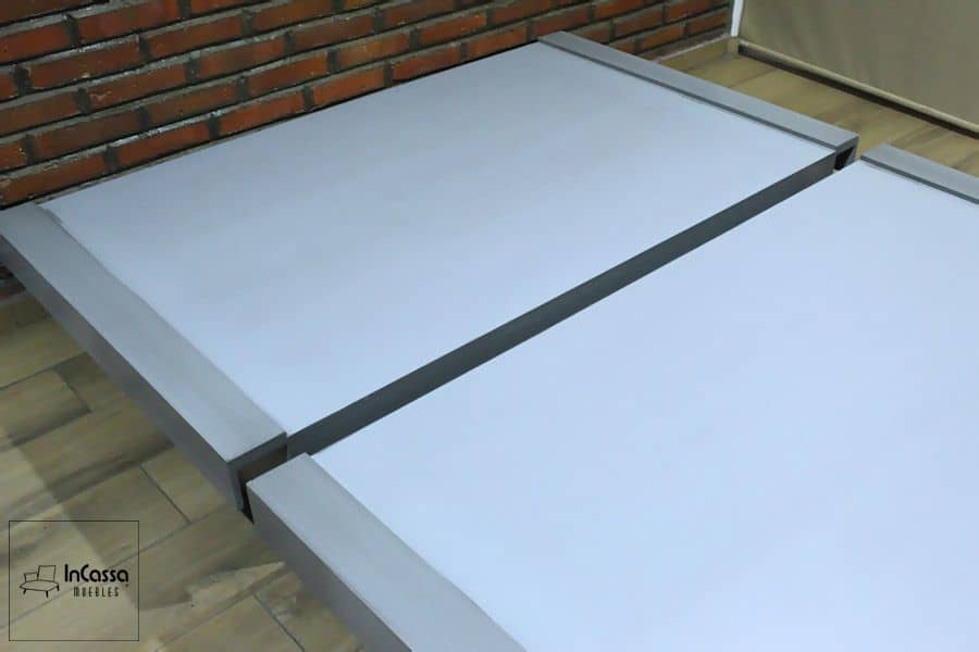 La imagen muestra un par de módulos que forma la base de cama en color gris cenizo claro con diseño modular y perfil bajo. Su superficie amplia y bordes elevados ofrecen un soporte firme y elegante, permitiendo configuraciones versátiles para diferentes necesidades de descanso.