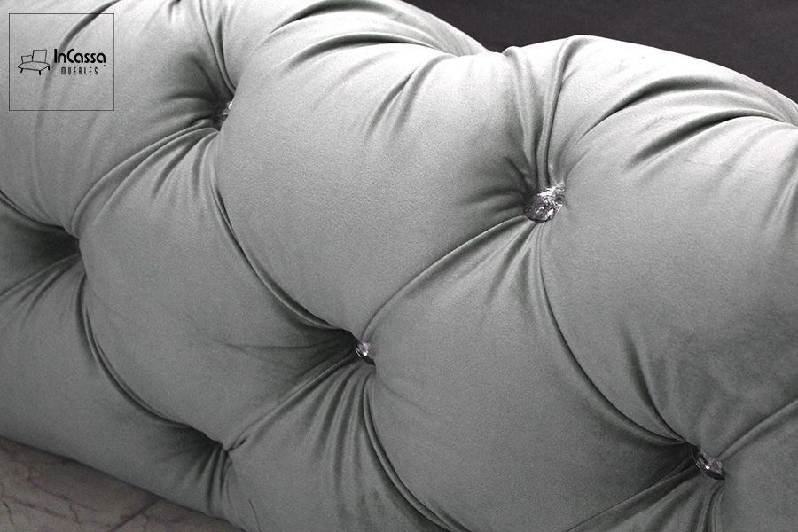 Una imagen con un mayor enfoque en los botones utilizados en el capitoneado del tapizado, los cuales tienen una bonita forma de diamante dándole un toque más sofisticado al tapiz suede gris perla.