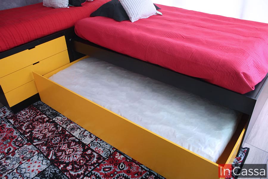 La toma destaca la base oculta de la trilitera. A diferencia del resto de la estructura del mueble, la cuál es de color chocolate, la base extra escondida es de color amarillo en su totalidad, y cuenta con un amplio espacio para instalar un colchón individual.