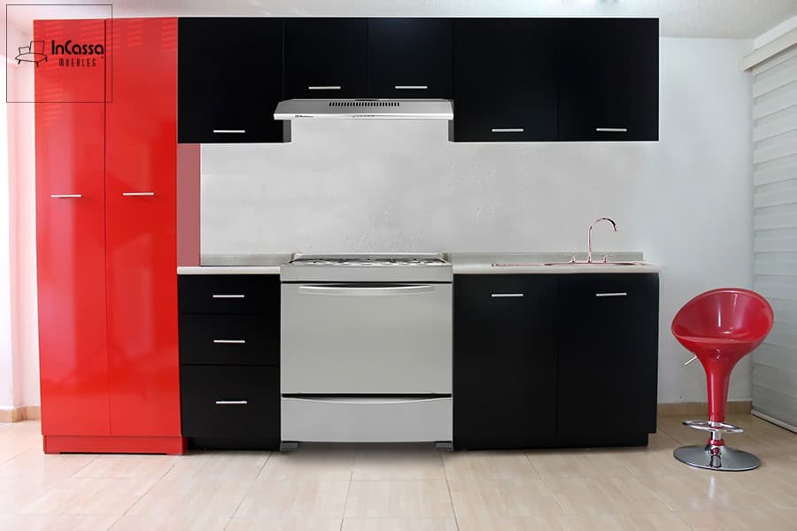 La imagen muestra una cocina integral moderna con módulos inferiores y superiores en color chocolate mate, combinados con un espectacular despensero lateral rojo de acabado brillante. La encimera clara contrasta sutilmente, mientras que los tiradores metálicos aportan un toque elegante.