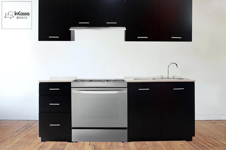 La foto muestra una composición completa de cocina lineal con muebles inferiores y alacenas en tono chocolate mate, jaladeras metálicas modernas y cubierta en formaica estilo granito de arena. La cocina incluye espacio para una estufa de 30” con campana de acero inoxidable, y cuenta con tarja con escurridor y grifería incluida. Un diseño elegante y funcional para interiores modernos.