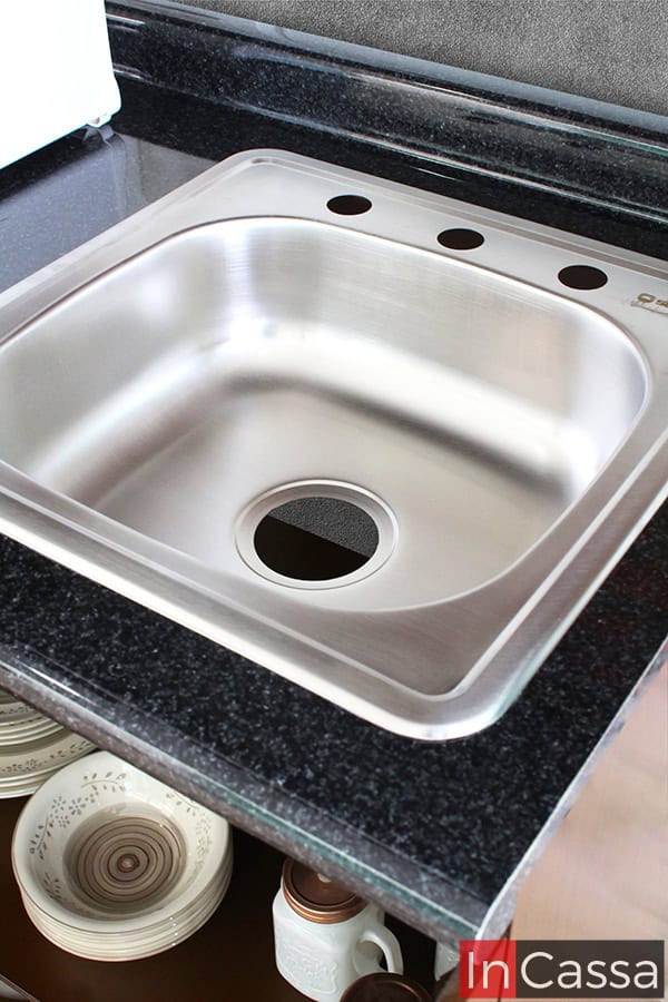 La tarja de acero inoxidable es resistente y duradera, con un diseño moderno y práctico para el día a día en la cocina. Perfecta para combinar con la cubierta de formaica en estilo mármol negro de la cocina.