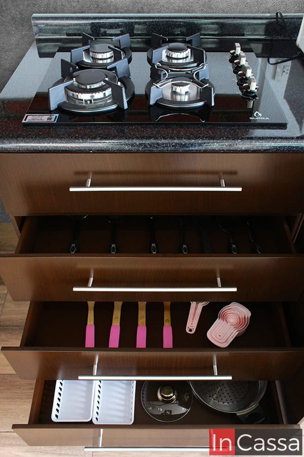 Los cajones abiertos en color tabaco completo exhiben el espacio ideal para almacenar utensilios de cocina, cucharas medidoras y más, manteniendo todo organizado y al alcance.