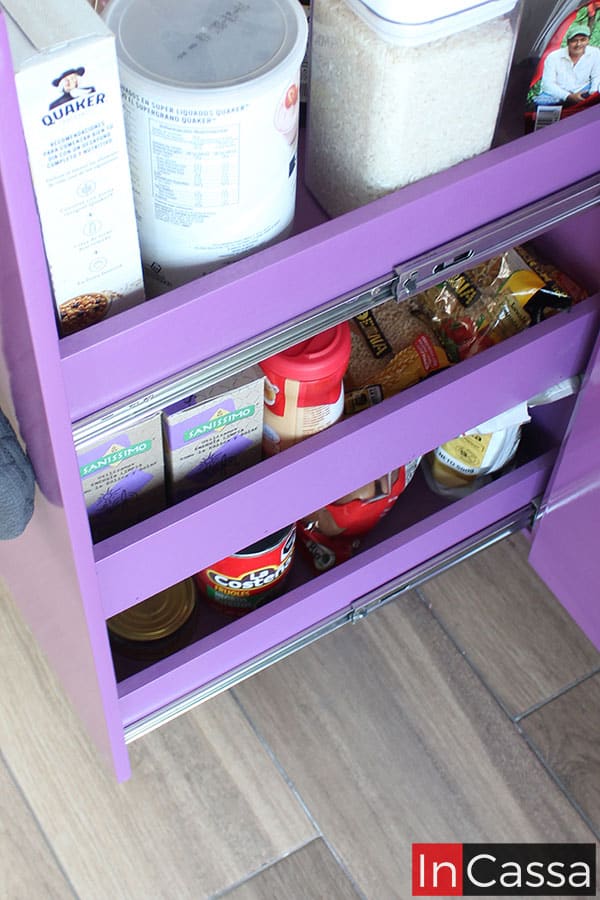 Una toma enfocada en el especiero integrado a la cocina, el cuál ofrece 3 espacios para especias, complementos y comidas enlatadas, todos mantienen el mismo tono uva que puede apreciarse en el resto de la cocina, además, el especiero cuenta con dos juegos de rieles metálicos para su apertura y cierre.