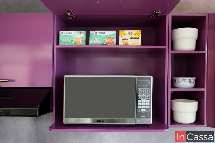 Imagen del módulo superior con espacio para microondas incluido en la cocina, en el que también se puede encontrar un pequeño compartimento. La estructura completa del módulo es de color uva en acabado brillante.